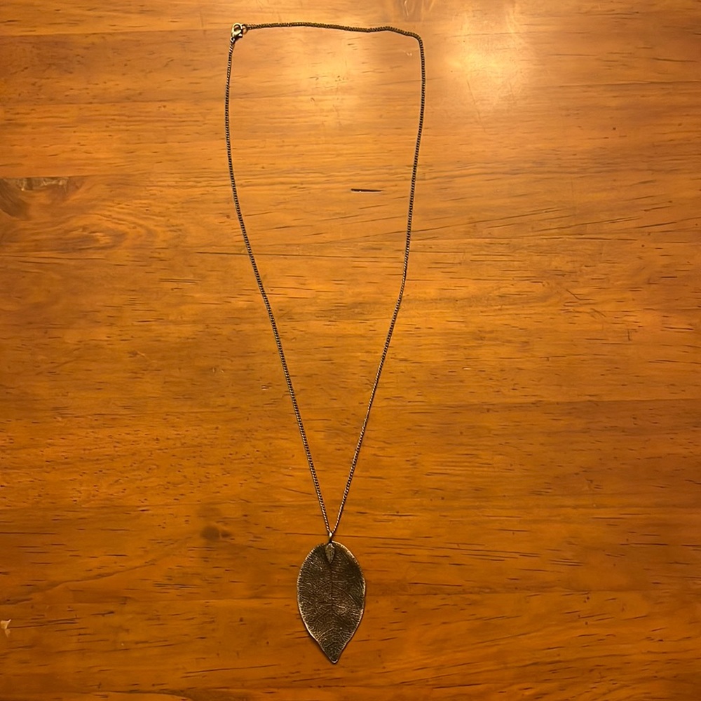 Silver colored leaf necklace detailed leaf pendant.